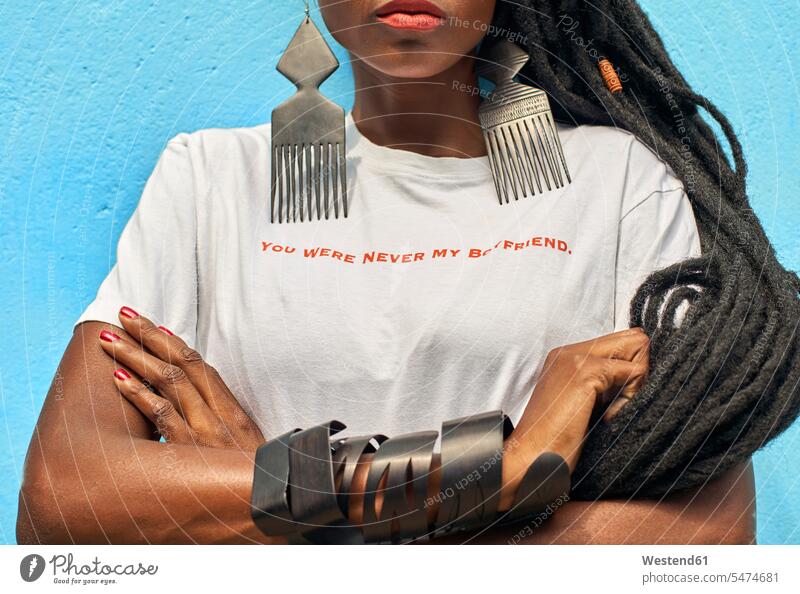 Portrait of woman with long dreadlocks wearing a T-shirt with the 'You were never my boyfriend' message on it in front of turquoise wall friends human