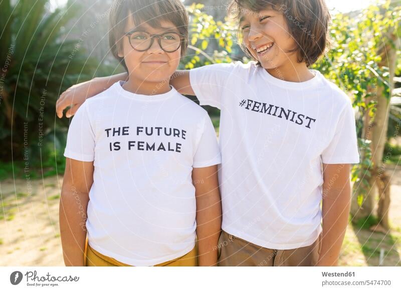 Two boys standing in the street with print on t-shirt, saying femininst and the future is female friends mate T- Shirt t-shirts tee-shirt smile delight