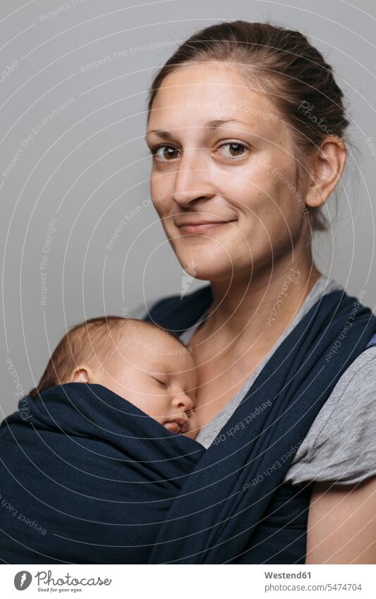 Portrait of smiling mother with baby in baby sling infants nurselings babies mommy mothers ma mummy mama smile slings baby slings people persons human being