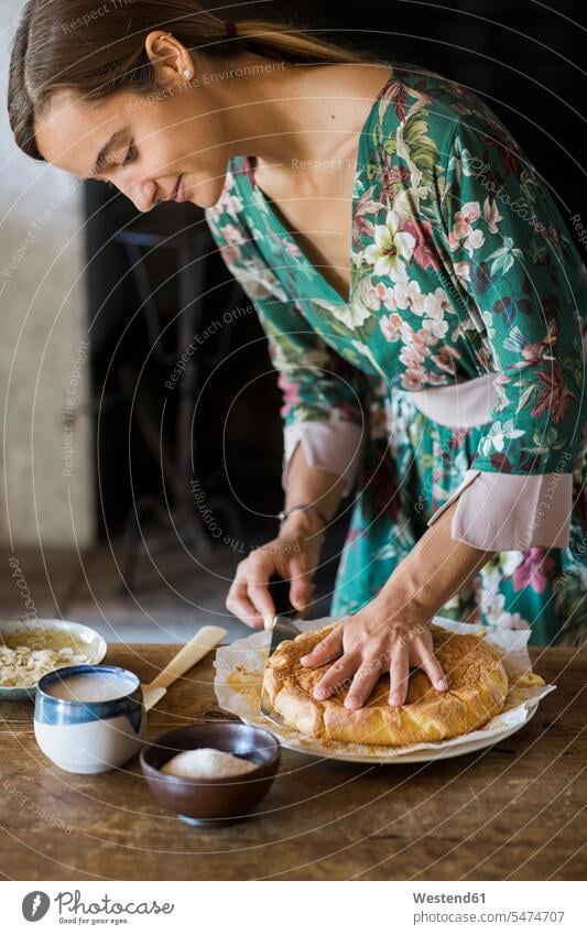 Young woman cutting home-baked cake pies cakes home-made females women Sweet Food sweet foods food and drink Nutrition Alimentation Food and Drinks Adults