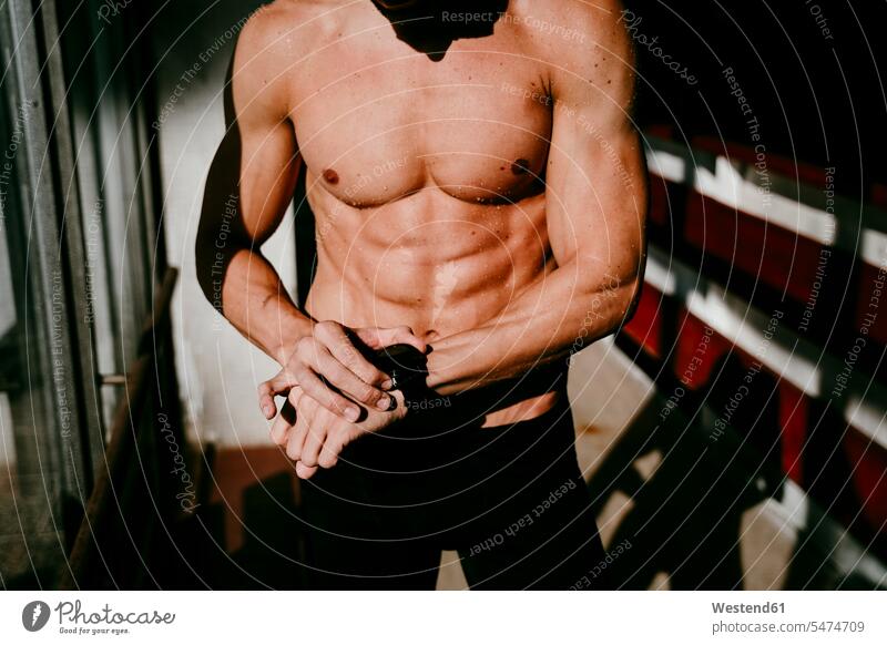 Swimmer checking time on smart watch while standing in locker room color image colour image indoors indoor shot indoor shots interior interior view Interiors