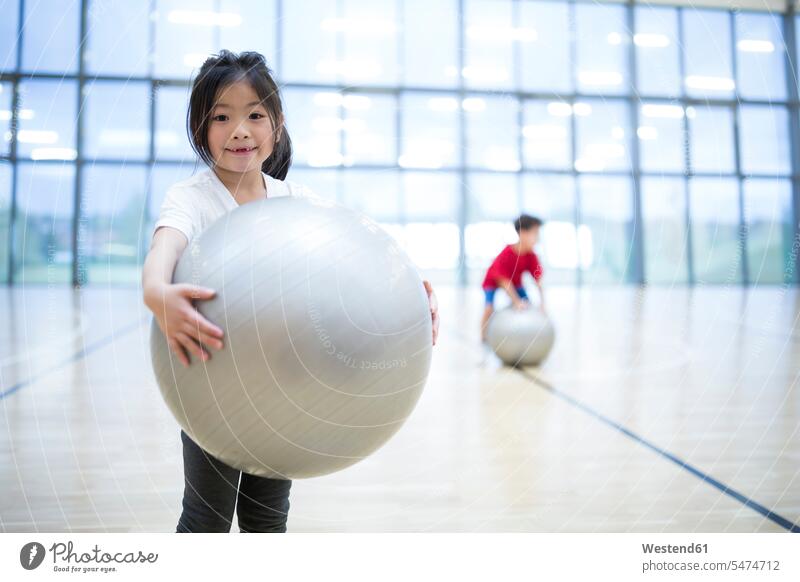Portrait of smiling schoolgirl holding gym ball in gym class schools Fitness Ball Fitness Balls Balance Ball exercise ball Stability Ball Gym Ball Swiss ball
