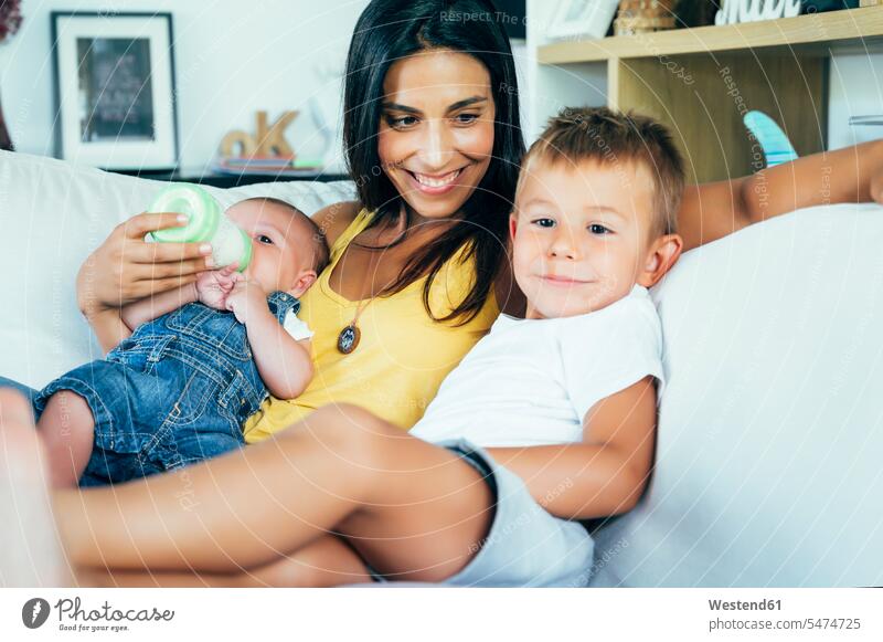 Mother with her two sons sitting on a sofa human human being human beings humans person persons caucasian appearance caucasian ethnicity european Group