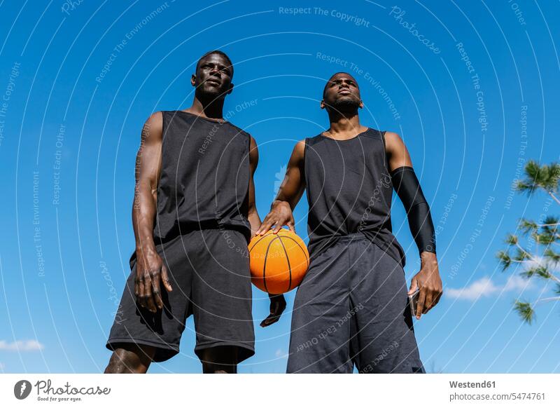 Young men holding basketball on basketball court human human being human beings humans person persons African black black ethnicity coloured 2 2 people