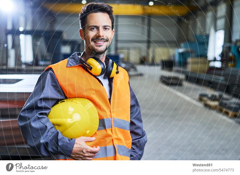 Portrait of smiling man wearing protective workwear in factory portrait portraits Protective Workwear Protective Work Wear men males smile Adults grown-ups