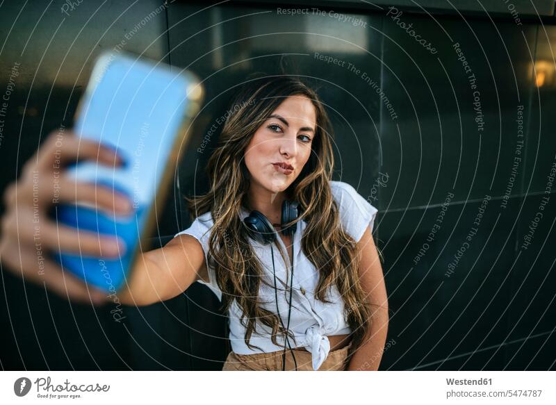 Young woman taking a selfie with her smartphone, pouting mouth human human being human beings humans person persons caucasian appearance caucasian ethnicity