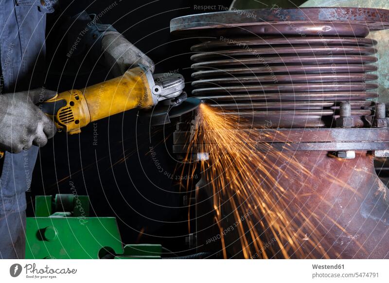 Close-up of worker using angle grinder in a factory human human being human beings humans person persons caucasian appearance caucasian ethnicity european 1
