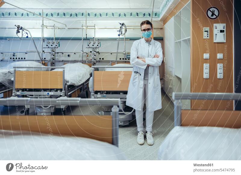 Portrait of doctor standing in hospital room Occupation Work job jobs profession professional occupation Bed - Furniture beds Eye Glasses Eyeglasses specs