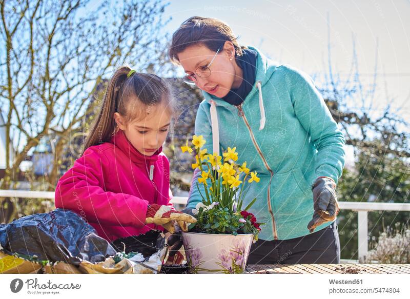 Mother and daughter planting flowers together on balcony human human being human beings humans person persons caucasian appearance caucasian ethnicity european