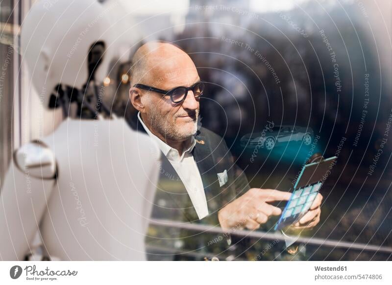 Senior businessman using digital tablet, looking for computerised cars human human being human beings humans person persons caucasian appearance