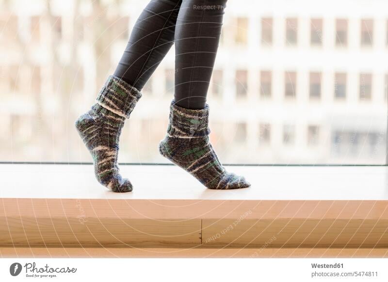 Woman wearing knitted socks balancing on window sill, partial view woman females women windowsill sills window sills Window Cill windowsills balance stocking