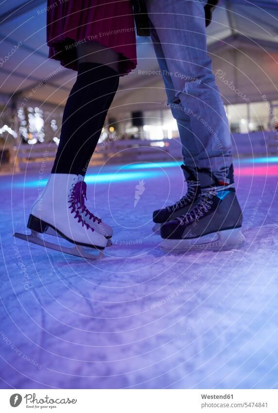 Legs of couple wearing ice skates standing on an ice rink twosomes partnership couples Ice Rink leg legs human leg human legs people persons human being humans