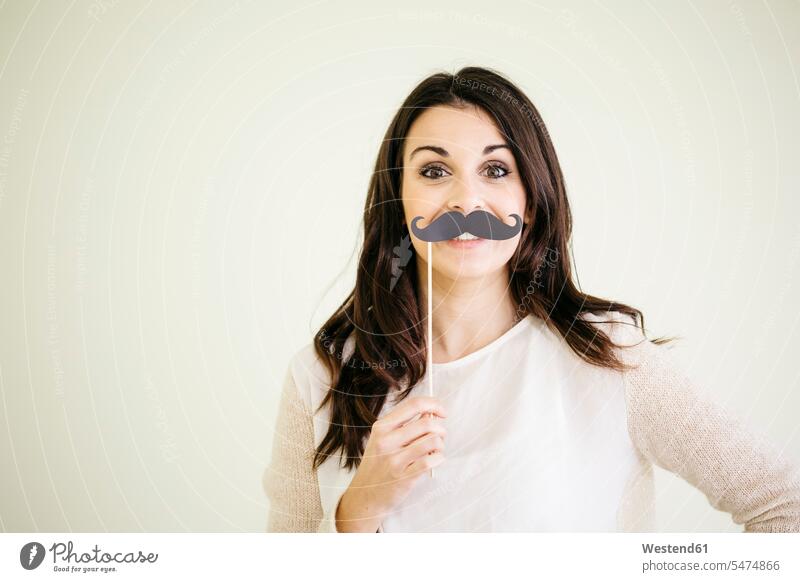 Portrait of young woman with fake moustache smile delight enjoyment Pleasant pleasure Cheerfulness exhilaration gaiety gay glad Joyous merry happy Emotions