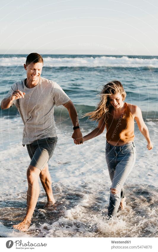 Happy young couple running at the seashore human human being human beings humans person persons caucasian appearance caucasian ethnicity european 2 2 people
