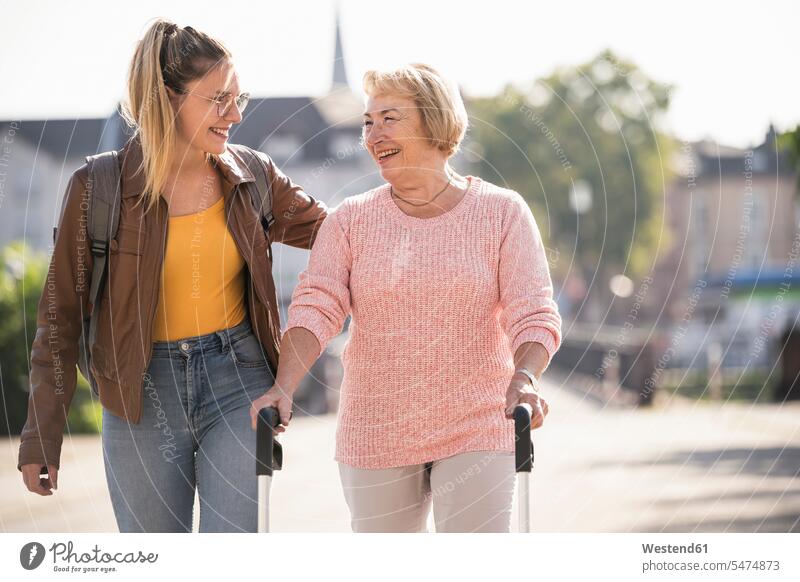 Granddaughter assisting her grandmother walking with wheeled walker generation jumper sweater Sweaters Eye Glasses Eyeglasses specs spectacles go going hold