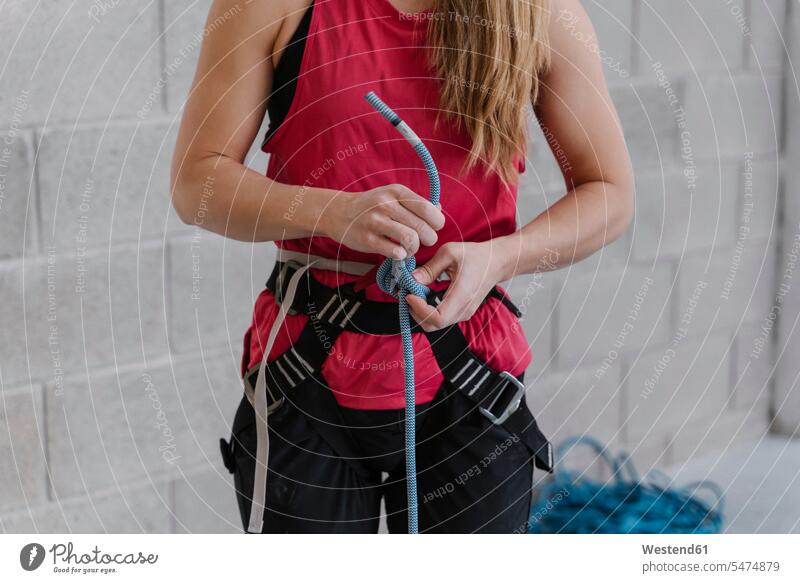 Crop view of a woman preparing for climbing (value=0) human human being human beings humans person persons caucasian appearance caucasian ethnicity european 1