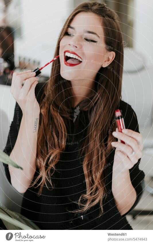 Portrait of happy young woman applying lipstick females women Lipstick Lipsticks happiness portrait portraits Adults grown-ups grownups adult people persons