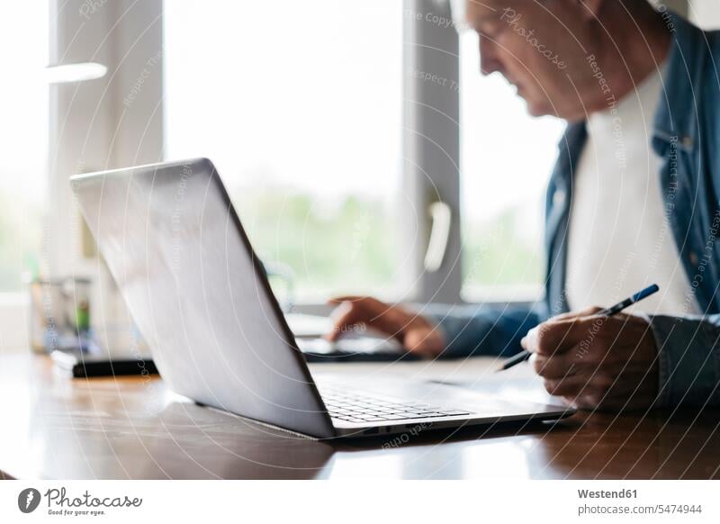 Senior man using calculator and laptop while writing at home color image colour image indoors indoor shot indoor shots interior interior view Interiors day
