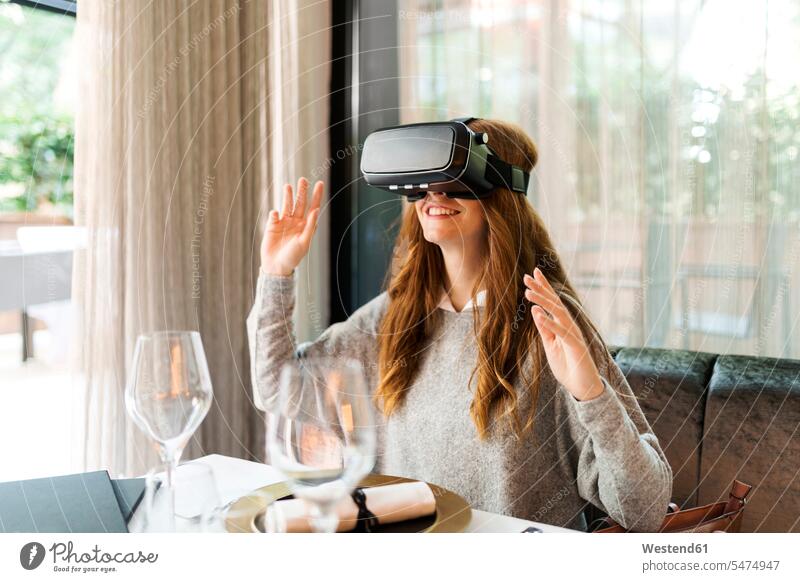 Woman sitting at table in a restaurant wearing VR glasses restaurants Virtual Reality Glasses Virtual-Reality Glasses virtual reality headset vr headset