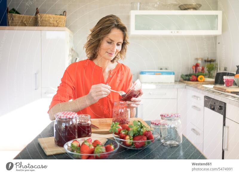Woman making strawberry jam in kitchen at home Jam Jelly Marmalade woman females women Spread Spreads Food foods food and drink Nutrition Alimentation