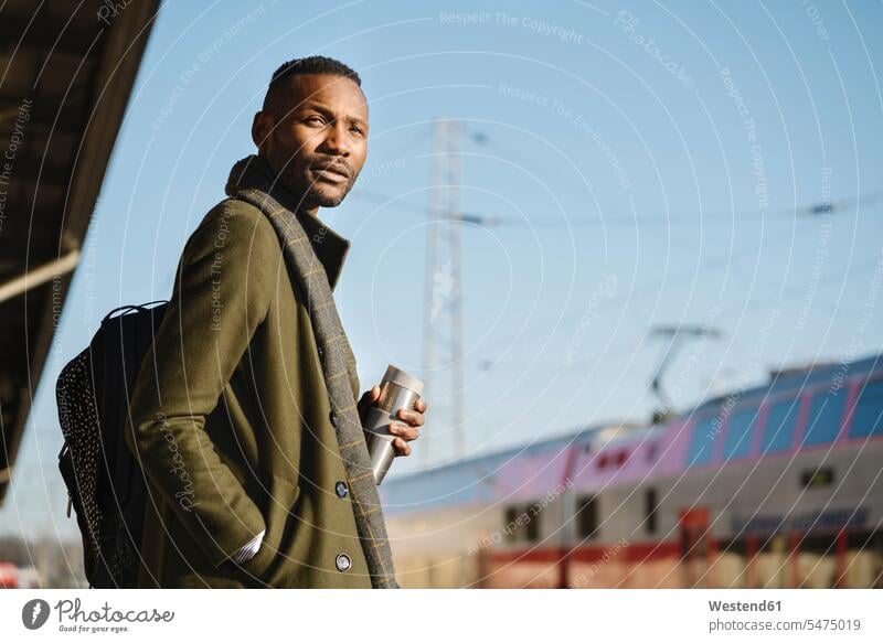 Stylish man with reusable cup waiting for the train business life business world business person businesspeople Business man Business men Businessmen human