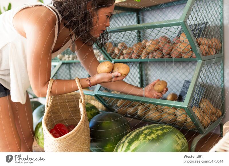 Young woman in organic store, choosing potatoes human human being human beings humans person persons Asian Asians Japanese 1 one person only only one person
