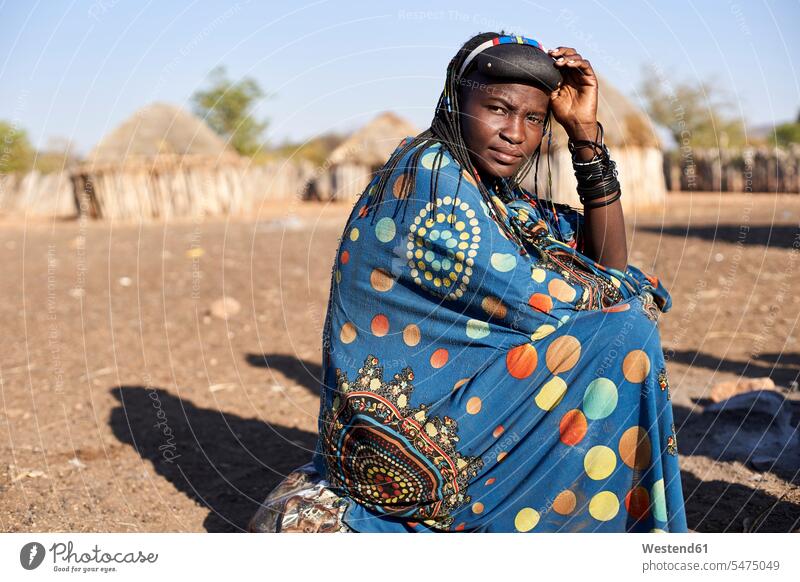 Portrait of a Muhacaona woman in her traditional colorful dress, Oncocua, Angola Seated sit colour colours colored coloured multi colored Multi Coloured