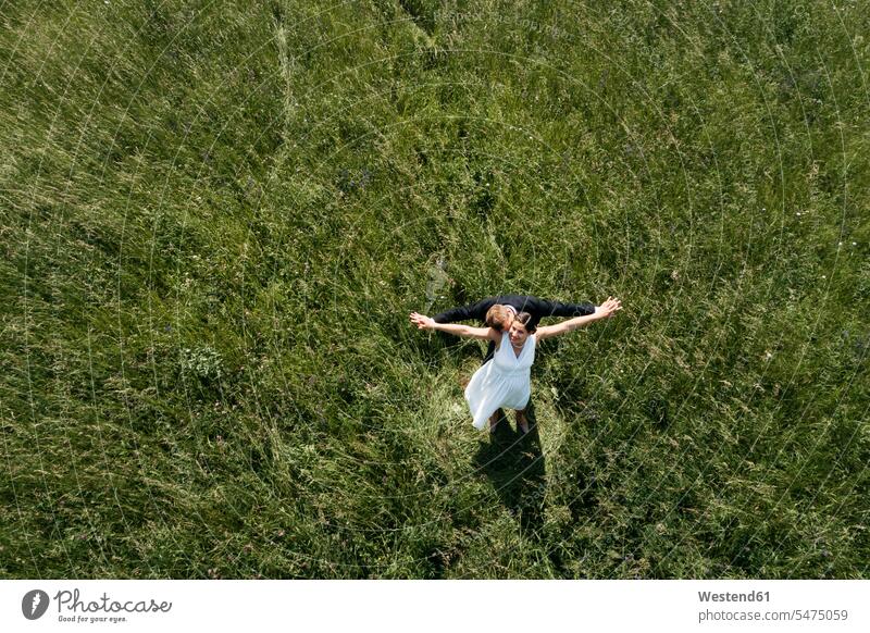 Aerial view of pregnant bride with her husband on a meadow human human being human beings humans person persons marriage matrimony couple married couples