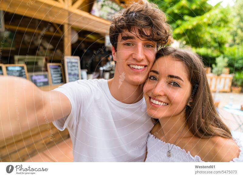 Young couple taking a selfie at a cafe human human being human beings humans person persons adult grown-up grown-ups grownup grownups young young adult