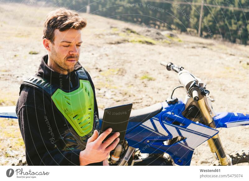 Portrait of motocross driver looking at tablet digitizer Tablet Computer Tablet PC Tablet Computers iPad Digital Tablet digital tablets eyeing Motocross