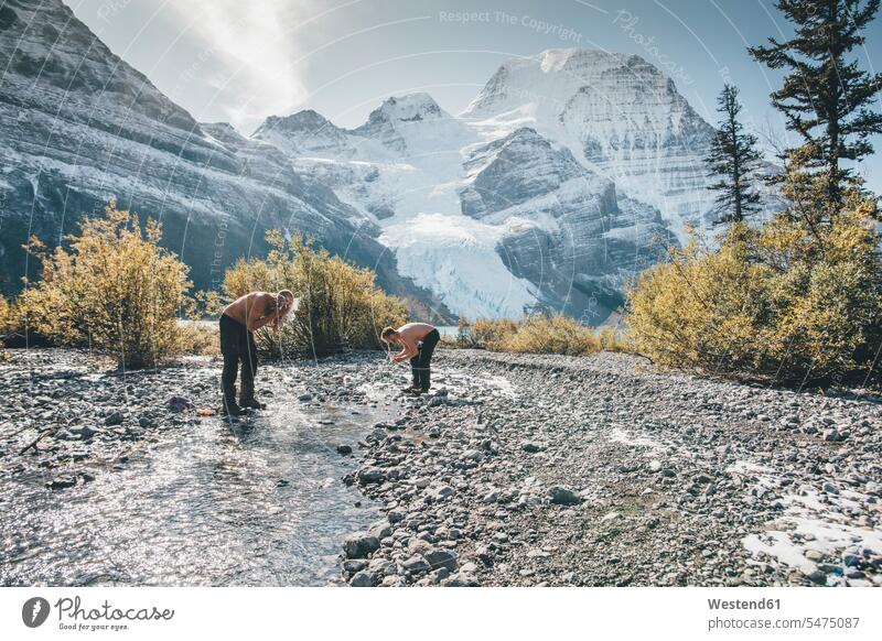 Canada, British Columbia, Mount Robson Provincial Park, two men washing in a brook man males brooks rivulet friends mate Adults grown-ups grownups adult people