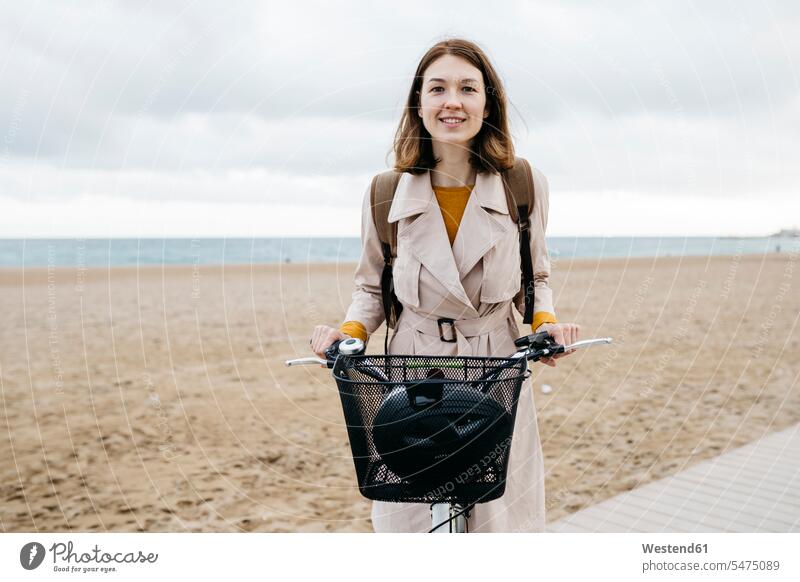 Portrait of smiling woman with e-bike at the beach beaches bicycle bikes bicycles smile E-Bike Electric bicycle Electric Bike portrait portraits females women