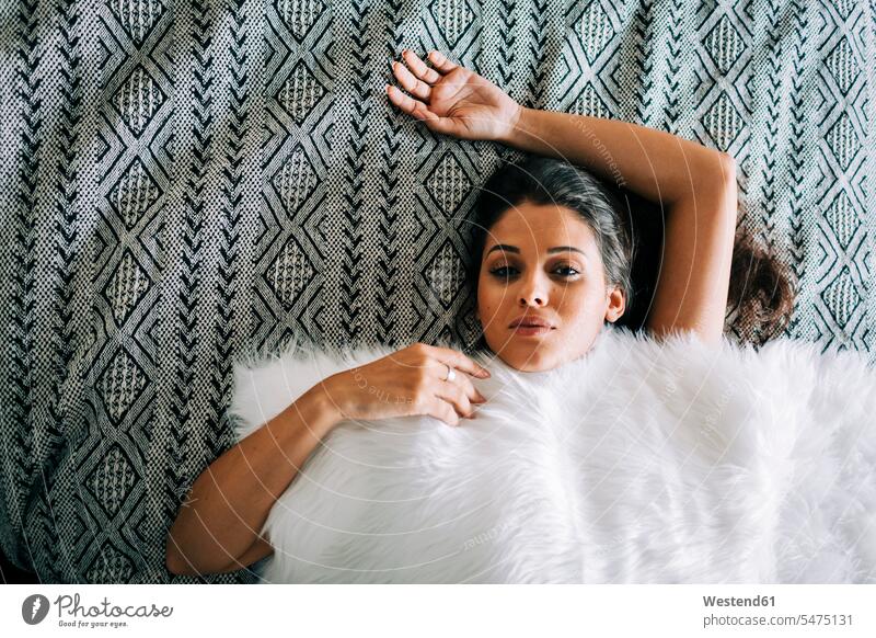 Close-up of young woman with fur blanket lying on bed at home color image colour image Portugal leisure activity leisure activities free time leisure time