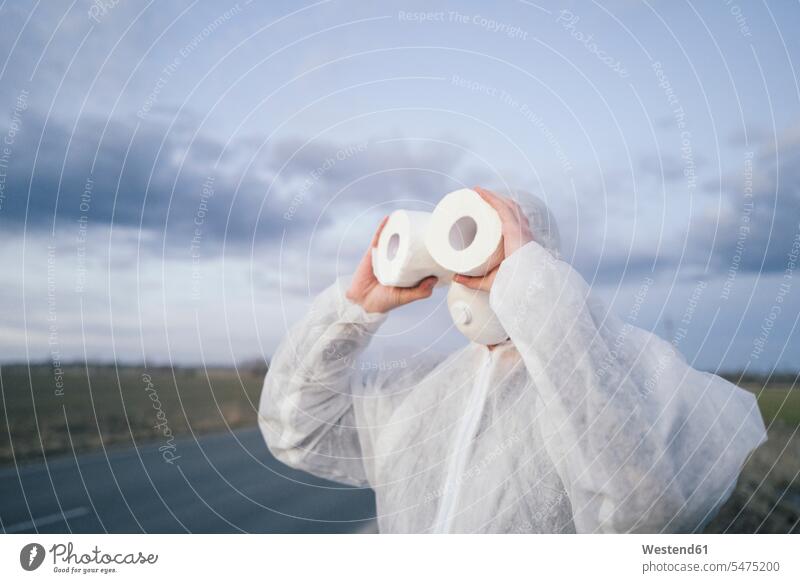 Man wearing protective suit and mask using toilet rolls like binoculars human human being human beings humans person persons 1 one person only only one person