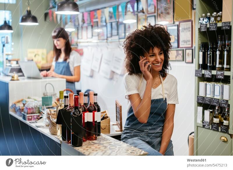 Smiling woman on the phone in a store females women mobile phone mobiles mobile phones Cellphone cell phone cell phones shop smiling smile call telephoning