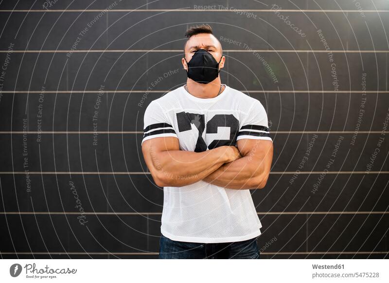 Macho young man wearing face mask standing against wall color image colour image Spain leisure activity leisure activities free time leisure time outdoors