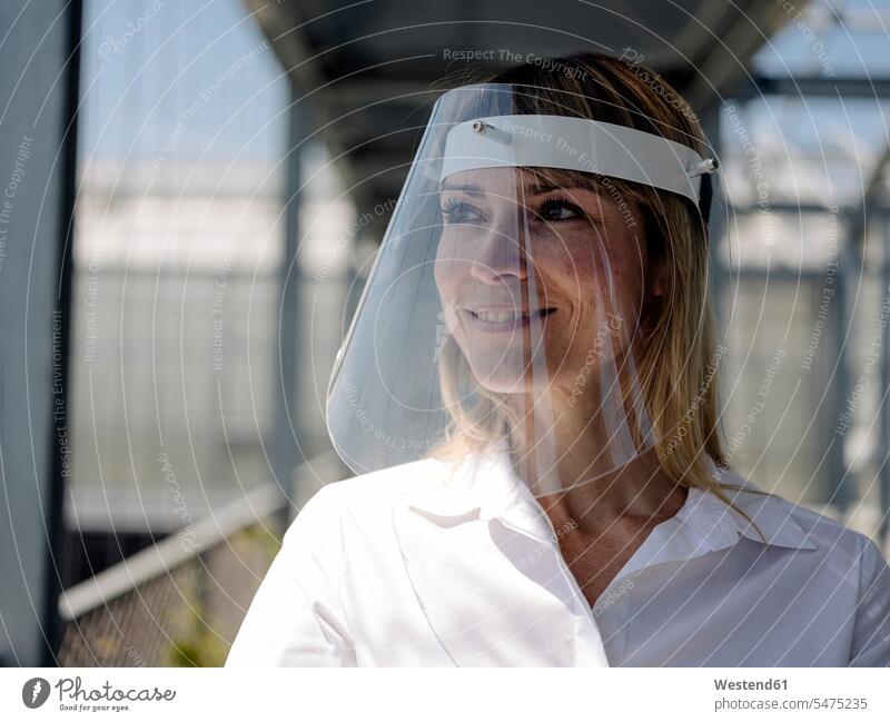 Close-up of businesswoman wearing face shield looking away in greenhouse color image colour image Germany business people businesspeople Business Professional