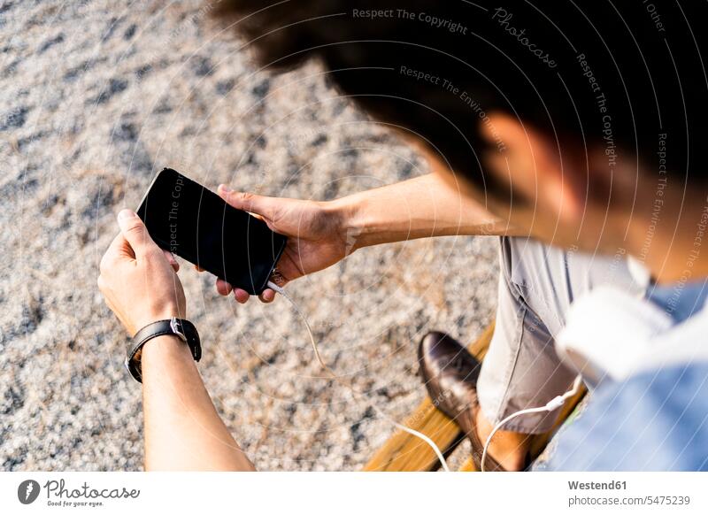 Close-up of man sitting on a park bench using his smartphone human human being human beings humans person persons caucasian appearance caucasian ethnicity