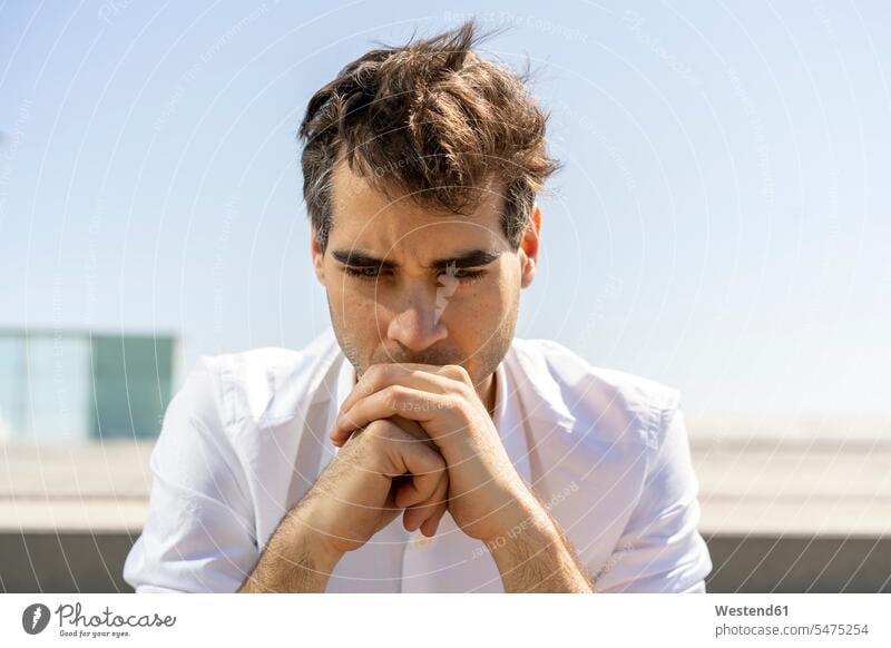 Portrait of serious businessman outdoors Barcelona thinking clear sky copy space cloudless blowing hair windswept Hair Blowing blowing hairs leaning rested on