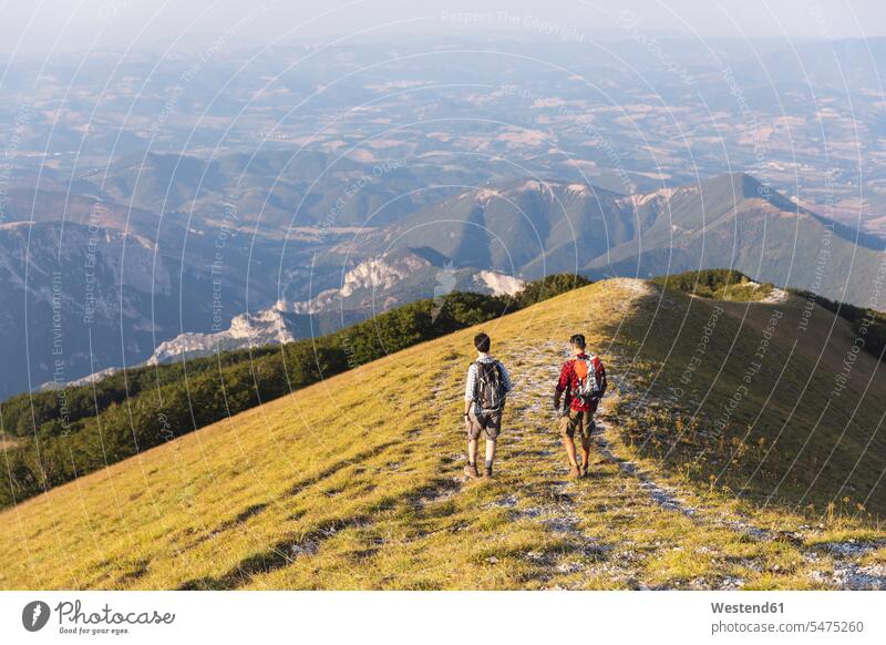 Italy, Monte Nerone, two men hiking on top of a mountain in summer hike mountains hiker wanderers hikers summit mountaintops summits mountain top man males