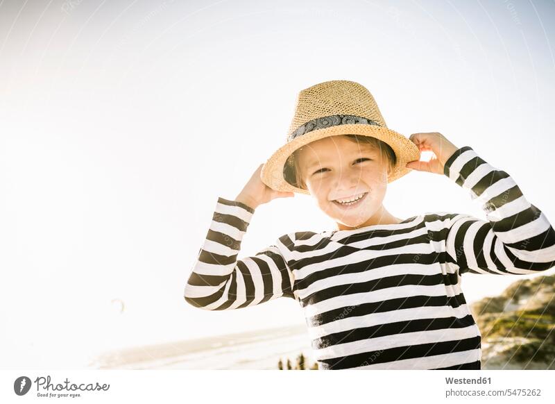 Portrait of happy boy with hat on the beach hats smile play seasons summer time summertime summery delight enjoyment Pleasant pleasure Cheerfulness exhilaration