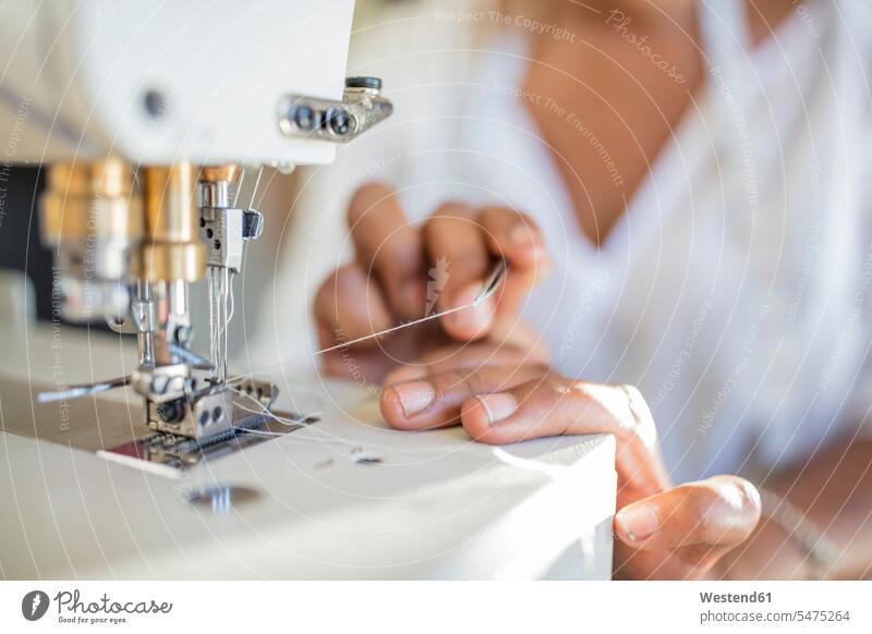 Close-up of woman using sewing machine females women seamstress seamstresses sewing machines working At Work Adults grown-ups grownups adult people persons
