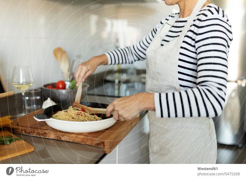 Close-up of woman cooking pasta dish in kitchen at home human human being human beings humans person persons celibate celibates singles solitary people