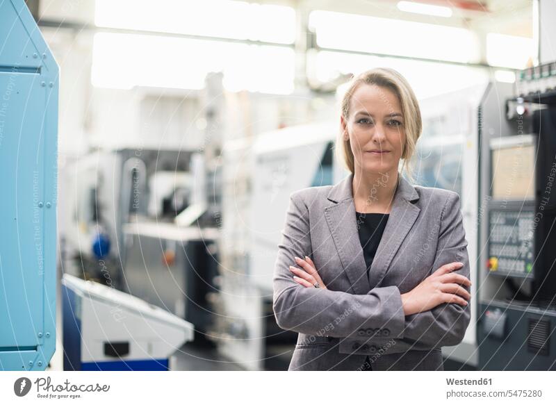 Portrait of confident woman in factory shop floor portrait portraits females women factories industrial hall factory hall industrial buildings confidence Adults
