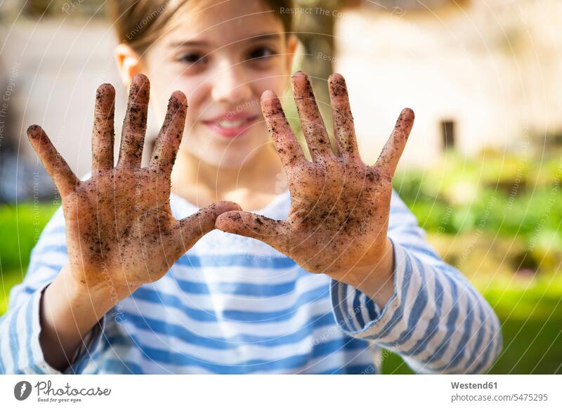 Portrait of smiling girl showing her dirty hands smile delight enjoyment Pleasant pleasure happy Contented Emotion pleased horticulture yard work yardwork