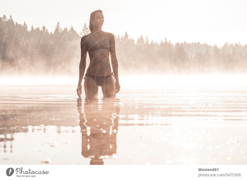Woman wearing bikini bathing in a lake at morning mist swim wear bikinis bathe Taking A Bath in the morning relax relaxing relaxation enjoy enjoyment indulgence