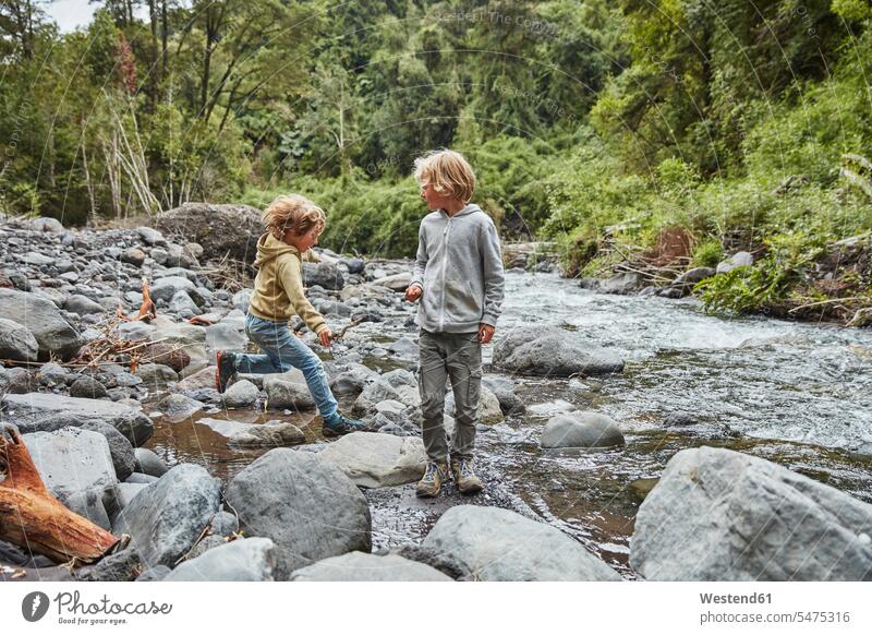 Chile, Patagonia, Osorno Volcano, Las Cascadas waterfall, two boys playing at a river River Rivers brother brothers males waters body of water siblings