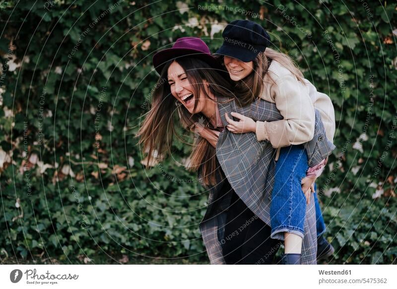 Laughing woman giving her friend a piggyback ride human human being human beings humans person persons caucasian appearance caucasian ethnicity european 2