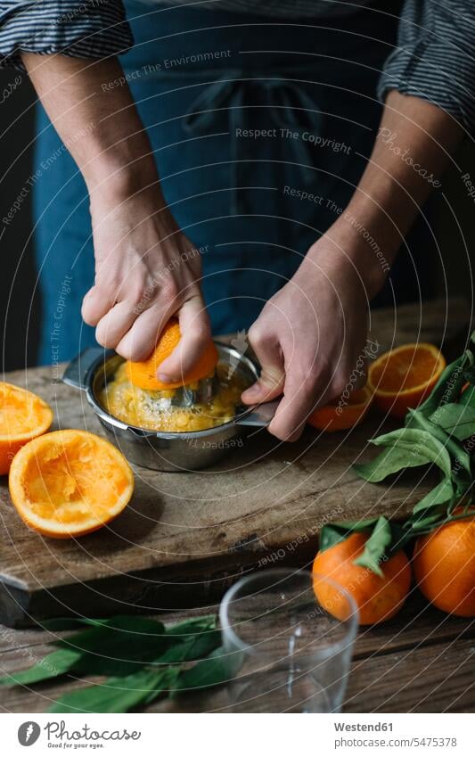 Young man's hands squeezing orange human hand human hands Orange Citrus sinensis Oranges men males squeese squeezed young people persons human being humans
