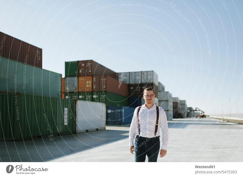 Manager in front of cargo containers on industrial site Spain exportation exporting import handling logistics company haulage company confidence confident